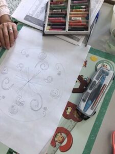 Un enfant dessine une sorte de carte mentale avec diverses formes au cours d'un séance de logopédie